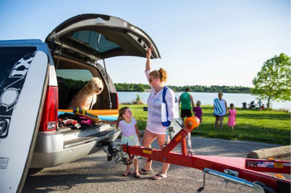Family unloading vehicle to enjoy camping outdoors