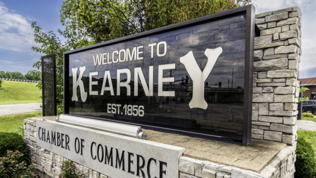 Welcome to Kearney sign sits above Kearney Chamber of Commerce sign in Kearney, MO