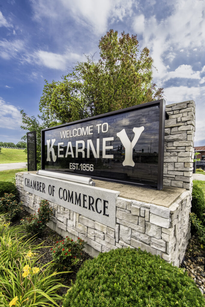 Welcome to Kearney sign sits above Kearney Chamber of Commerce sign in Kearney, MO